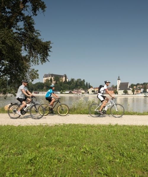 Cyclistes sur la piste du Danube au pied d'un château perché - Autriche
