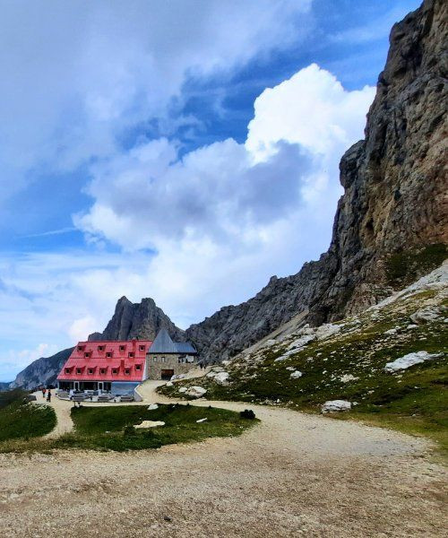 Refuge au toit rouge au pied des falaises des Dolomites - Italie